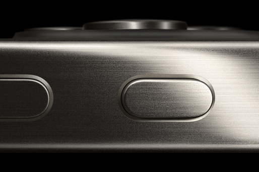 Dettaglio della parte laterale di un iPhone 15 Pro, dove si notano il profilo in titanio, il tasto Azione e il tasto per alzare il volume